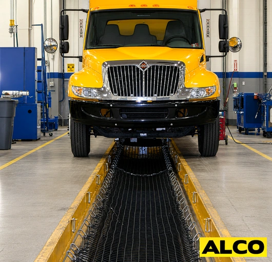 A commercial grade safety net used to catch spills and debris during oil changes in a garage or service bay setting.